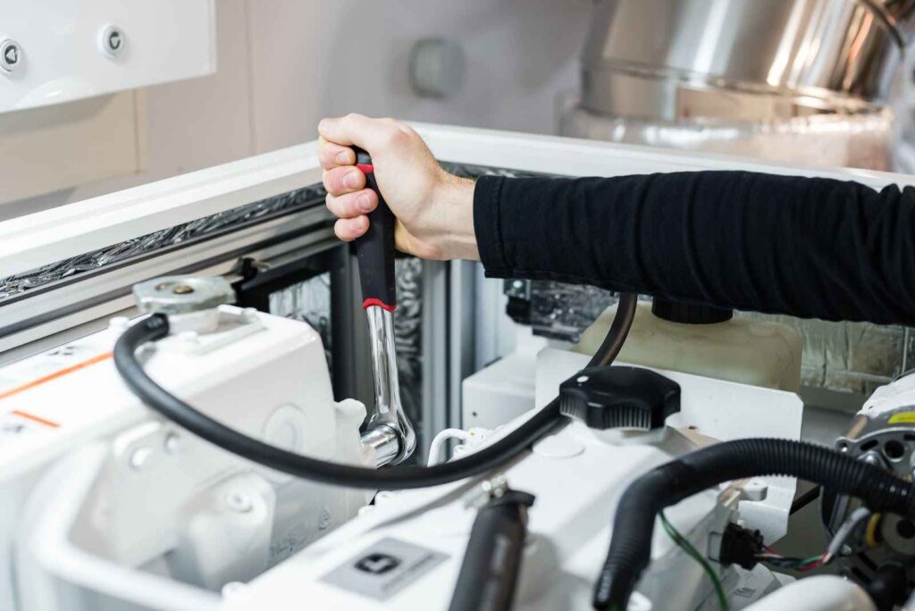 Human arm using a rachet socket tool to adjust bolts on machine