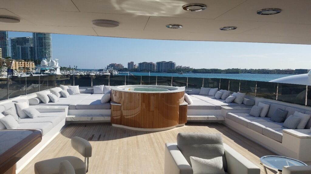 White and grey yacht furnishings on a yacht deck, with a hot tub in the center