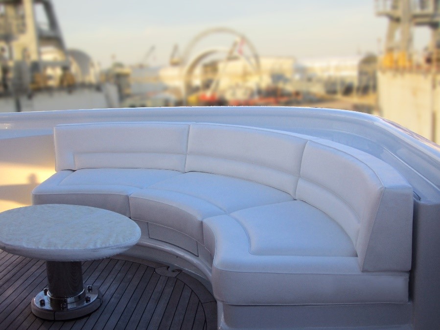 White leather yacht upholstery corner bench sofa with a white round table in front