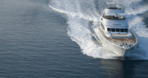 White yacht cursing through the water leaving a trail of white water