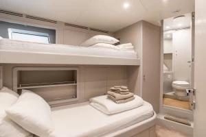 Compact and efficient crew quarters featuring bunk beds with crisp linens and personal storage spaces, ensuring comfort and organization for onboard staff.