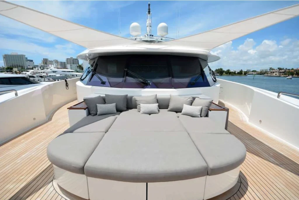 Yacht sail awnings fanning both left and right over grey yacht furnishings and cushions.