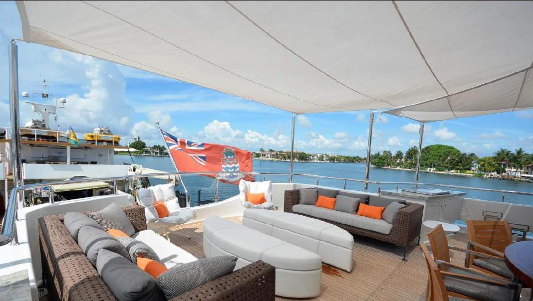 Yacht sail awning over grey and white yacht cushions and sofas on the yacht deck.