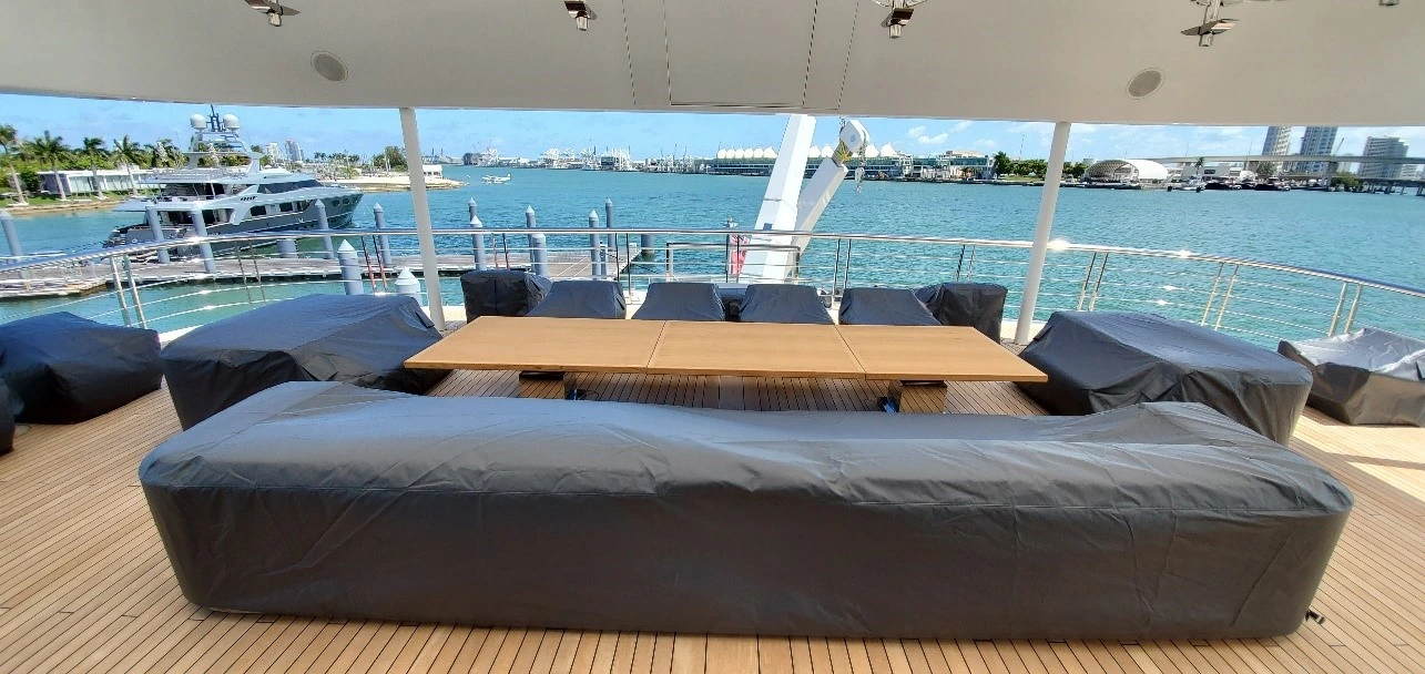 Set of yacht furnishings with black yacht covers on the exterior deck of a superyacht.