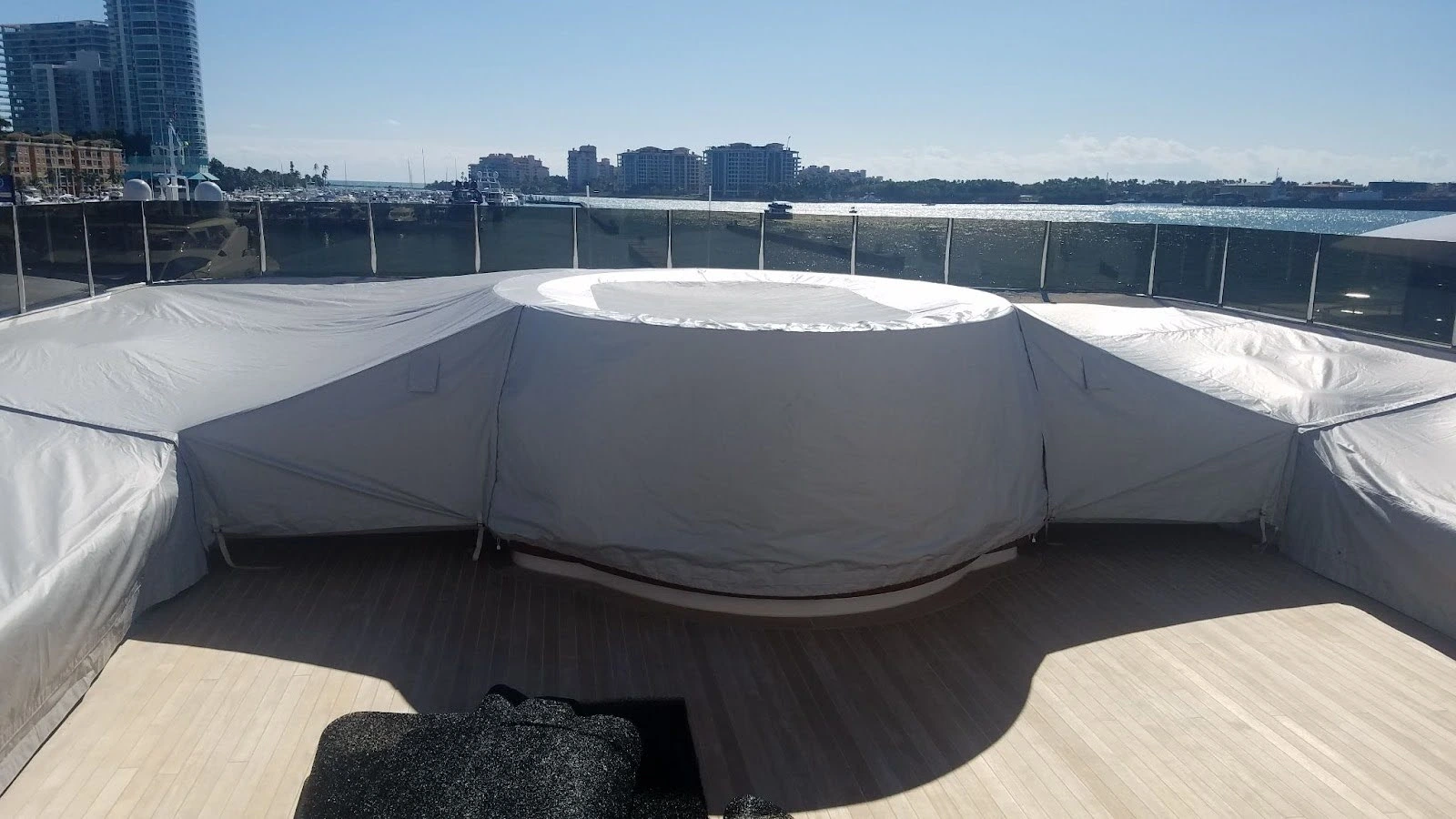 Hot tub and superyacht furnishings under grey weather yacht covers.
