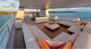 Exterior yacht deck with white yacht sofas, cushions, upholstery and furnishings spread around.