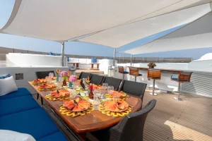 Sun awning over yacht deck with dining table.